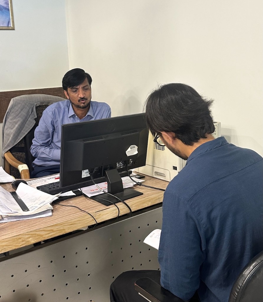 Discussing research findings with branch staff at a desk during a field visit